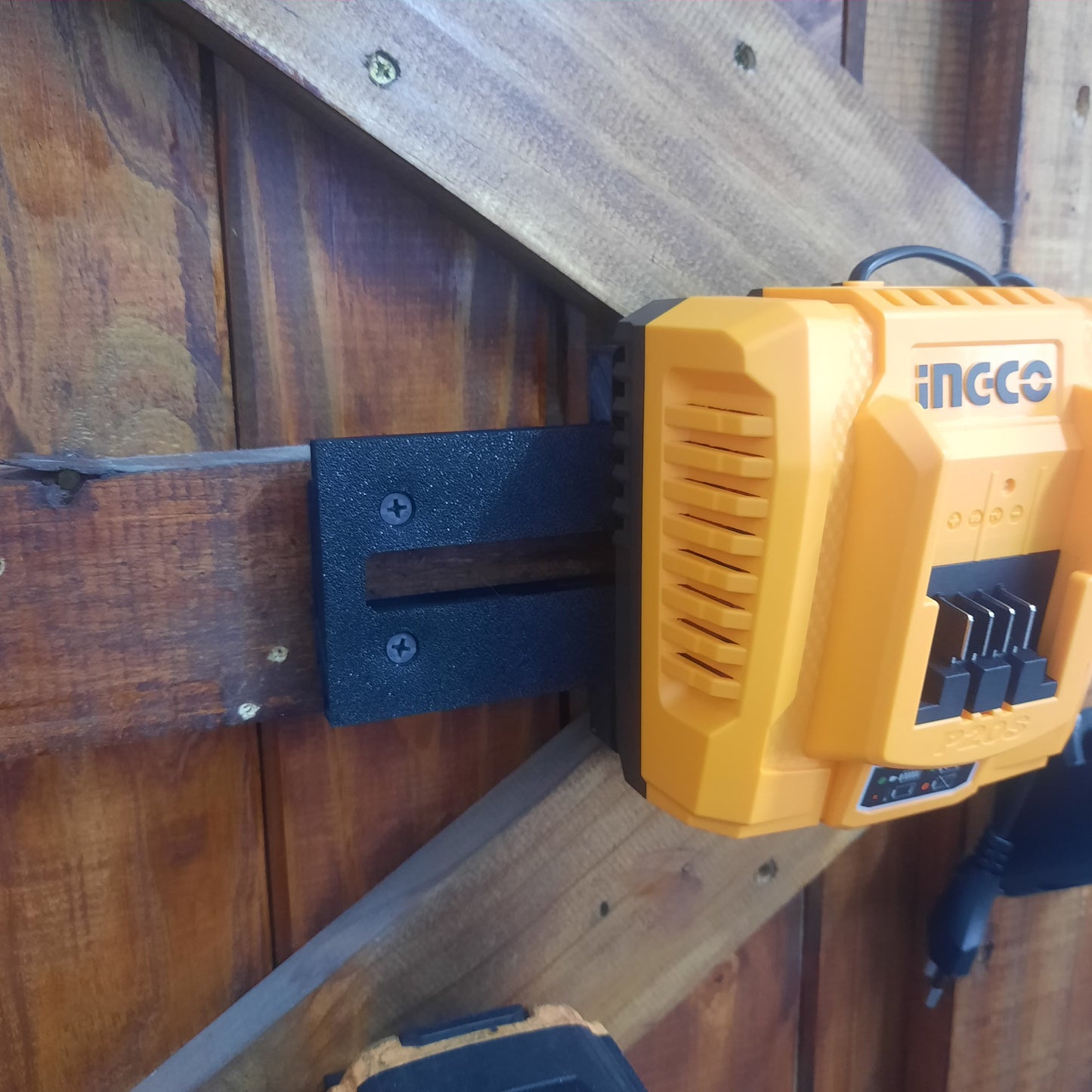 INGCO charger sliding onto the wall mounted bracket